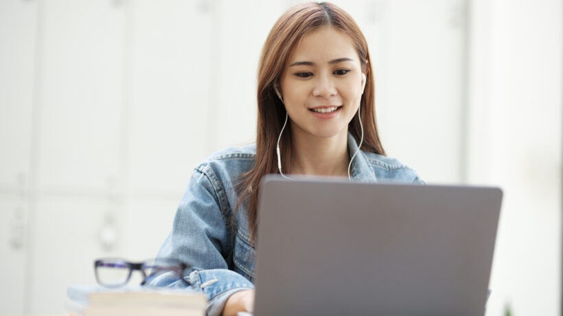 Studentka UŚ przed laptopem, przeglądająca platformę USOS UŚ